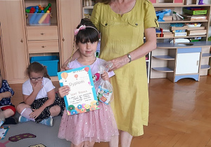 Lenka otrzymuje dyplom i nagrodę.